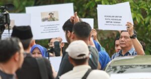 Family hold placards calling for justice as Palapes cadet's grave is exhumed