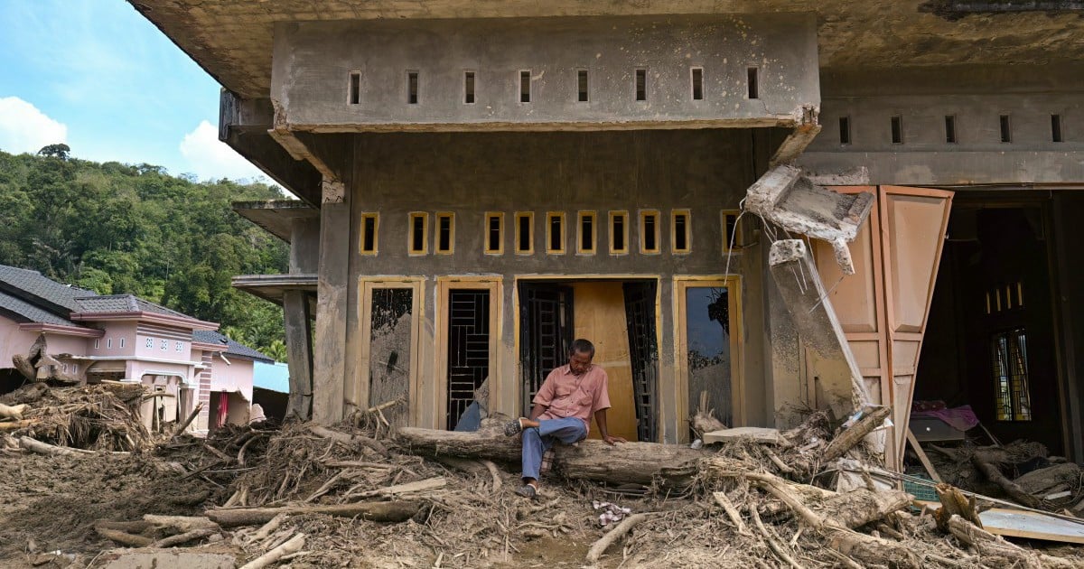 Indonesians climb over logs in walk to aid centre as flood deaths rise over 900